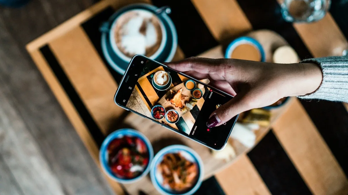 Gość fotografuje telefonem śniadanie w hotelowej restauracji